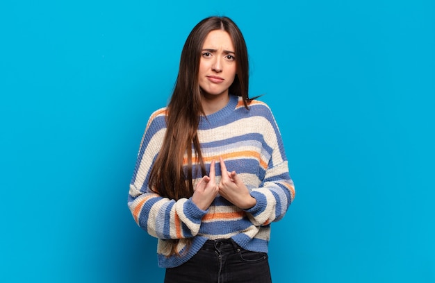 Junge hübsche lässige Frau, die mit einem verwirrten und fragenden Blick auf sich selbst zeigt, schockiert und überrascht, ausgewählt zu werden