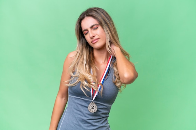 Junge hübsche Sportlerin aus Uruguay mit Medaillen vor isoliertem Hintergrund mit Nackenschmerzen