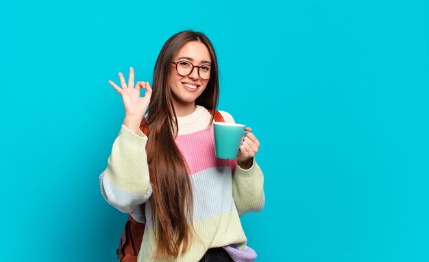 Junge hübsche Studentin Frau mit einer Kaffeetasse