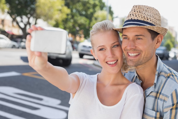 Junge Hüftepaare, die ein selfie nehmen