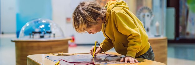 Foto junge im naturwissenschaftlichen unterricht das kind beschäftigt sich mit wissenschaftsbannern im langformat