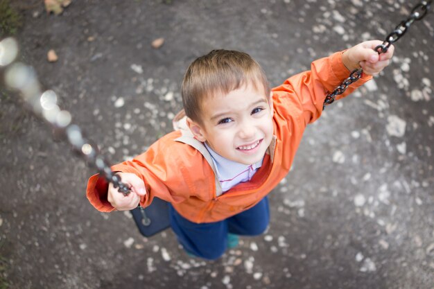 Foto junge im park auf schwingen