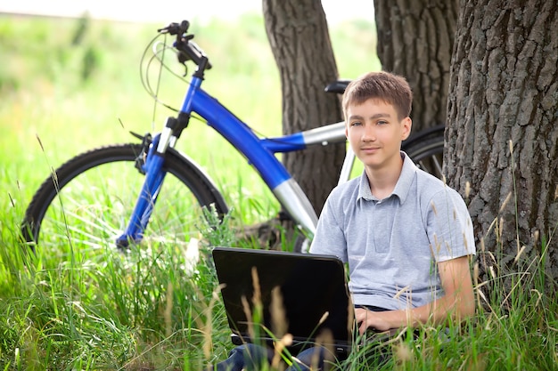 Junge im Park mit Laptop