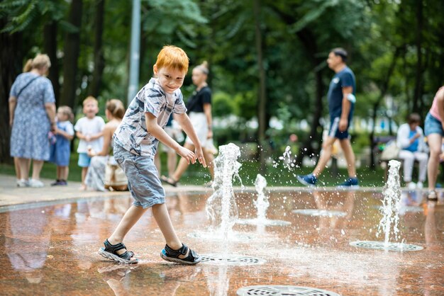 Junge im Sommer Brunnen im Park Sommerferienzeit