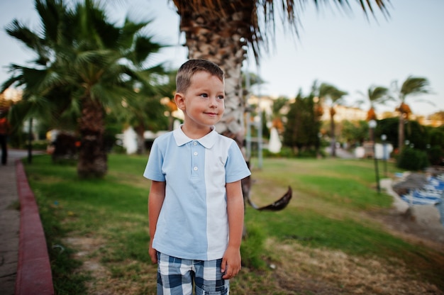 Junge im Türkei-Resort gegen Palmen.