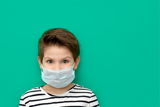 Junge in der medizinischen Maske, die während des Coronovirus isoliert wird.