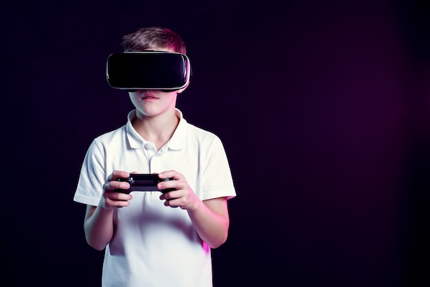 Junge in der VR-Schutzbrille, die mit gamepad spielt