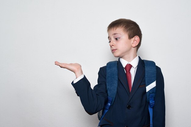 Junge in Schuluniform hält eine Hand Weißer Hintergrund Bildung für Kinder Kopieren Sie Platz