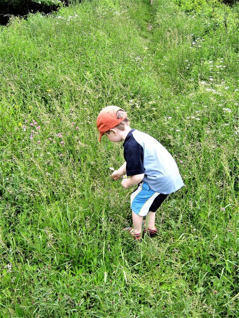 Foto junge in voller länge steht auf einem grasbewachsenen feld