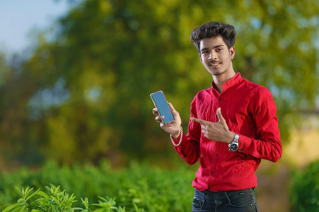 Junge indische Bankleitung am Feld mit Laptop