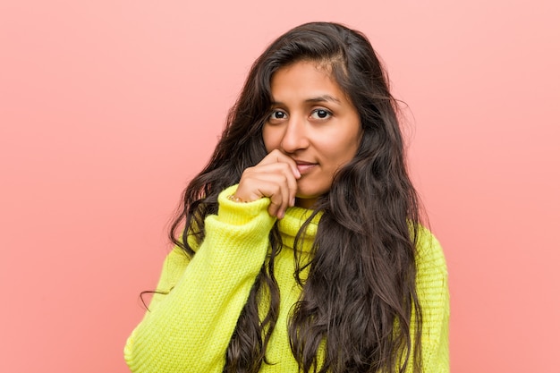 Junge indische Frau gegen einen rosa Hintergrund