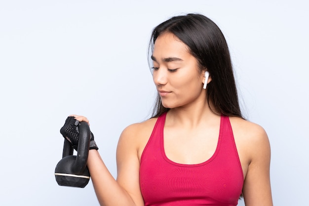 Junge indische Sportfrau blau, die Gewichtheben mit Kettlebell macht