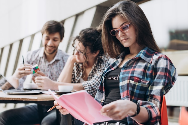 Junge intelligente Leute benutzen Gadgets beim Studieren in der modernen Bibliothek