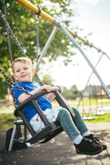 Junge Junge lächelt und schwingt sich im Park