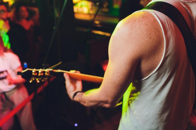 Junge Junge spielt Akustikgitarre in einer Hall.