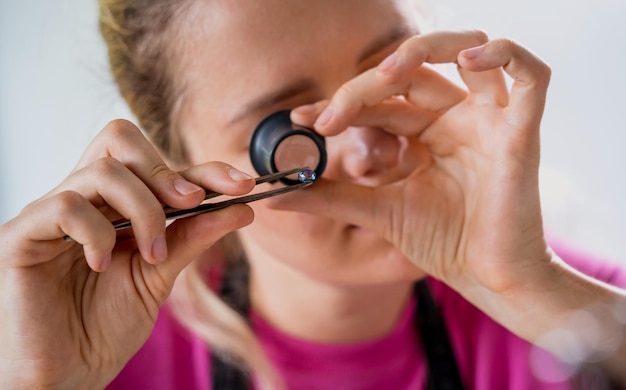 Junge Juwelierin stellt in der Werkstatt Schmuck her