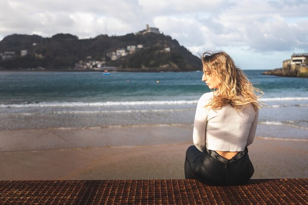 Junge kaukasische blonde Frau am Pier des Baskenlandes Donostia-San Sebastian.