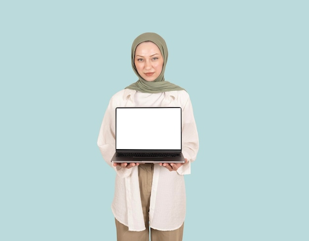 Junge, kaukasische, charmante muslimische Frau hält einen Laptop mit leerem Bildschirm, PC-Notebook-Mockup