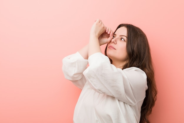 Junge kaukasische curvy Frau, die gegen Rosa steht