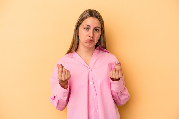 Junge kaukasische Frau auf gelbem Hintergrund isoliert, die zeigt, dass sie kein Geld hat.