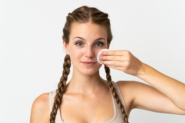 Junge kaukasische Frau auf Weiß mit Wattepad zum Entfernen von Make-up von ihrem Gesicht