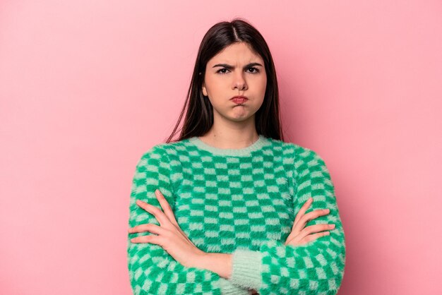 Junge kaukasische Frau, die auf rosafarbenem Hintergrund isoliert ist, bläst Wangen und hat einen müden Ausdruck Gesichtsausdruck-Konzept