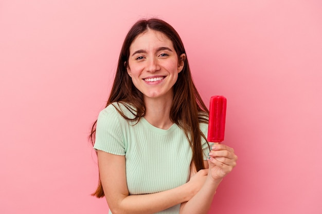 Junge kaukasische Frau, die ein Eis hält, lacht und hat Spaß.