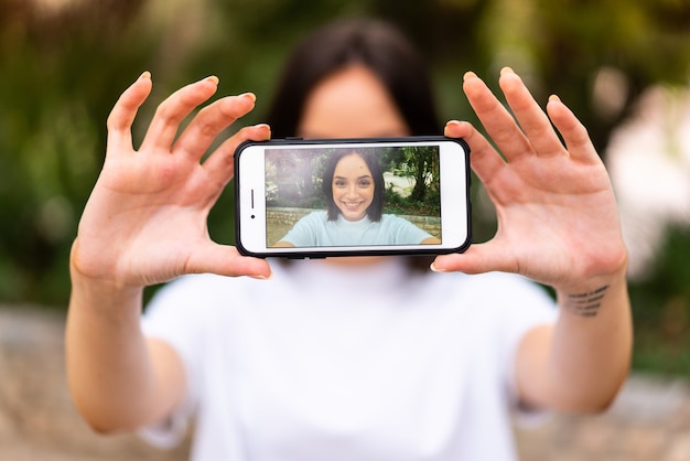 Junge kaukasische Frau, die ein selfie im Freien macht