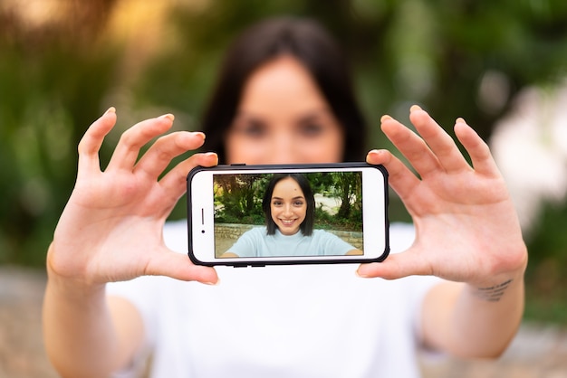 Junge kaukasische Frau, die ein selfie im Freien macht