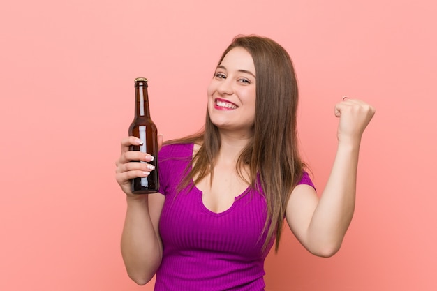 Junge kaukasische Frau, die eine Bierflasche anhält