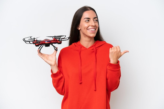 Junge kaukasische Frau, die eine Drohne lokalisiert auf weißem Hintergrund hält