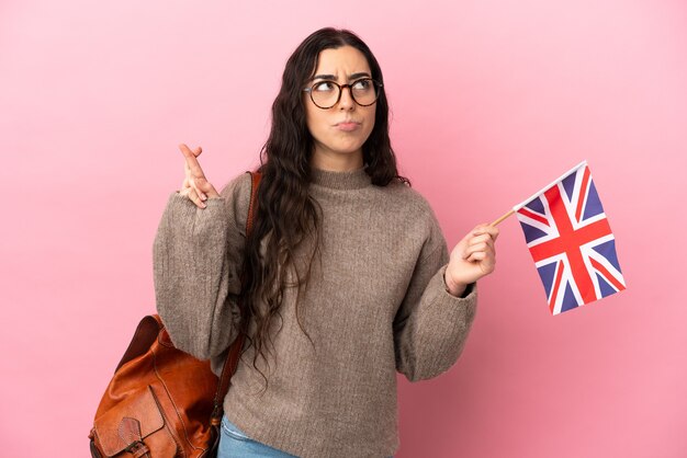 Junge kaukasische Frau, die eine Flagge des Vereinigten Königreichs isoliert hält