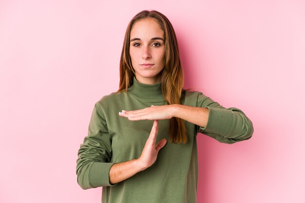 Junge kaukasische Frau, die eine Zeitüberschreitungsgeste darstellend aufwirft.