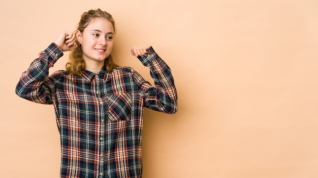 Junge kaukasische Frau, die einen besonderen Tag feiert, springt und hebt Arme mit Energie.