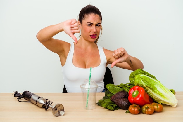 Junge kaukasische Frau, die einen gesunden Smoothie mit Gemüse zubereitet