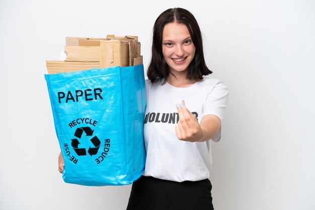 Junge kaukasische Frau, die einen Recycling-Beutel voller Papier hält, um isoliert auf weißem Hintergrund zu recyceln, Geld verdienen Geste