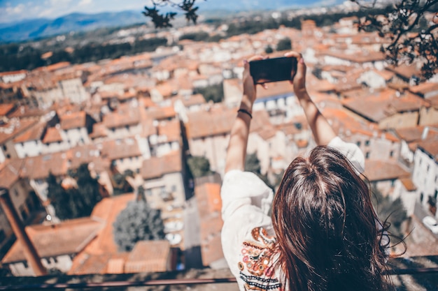 Junge kaukasische Frau, die Foto durch Handy vom Beobachtungsplatz macht