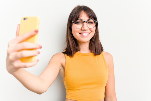 Junge kaukasische Frau, die Handy lokalisiert auf weißem Hintergrund verwendet