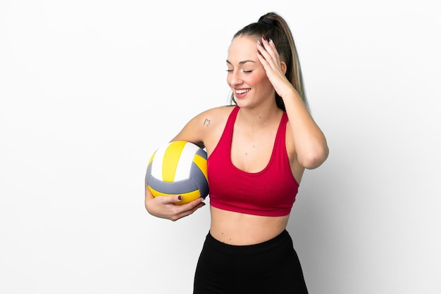 Junge kaukasische Frau, die Volleyball spielt, isoliert auf weißem Hintergrund, lächelt viel