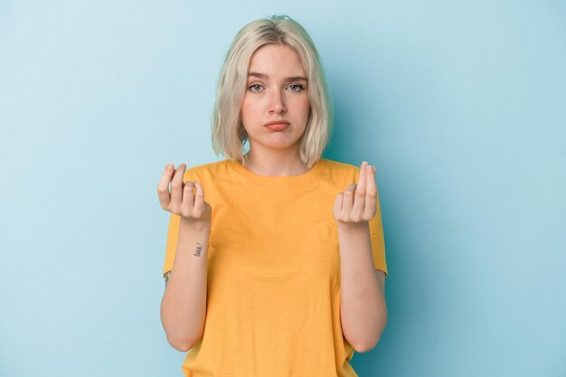 Junge kaukasische Frau isoliert auf blauem Hintergrund, die zeigt, dass sie kein Geld hat