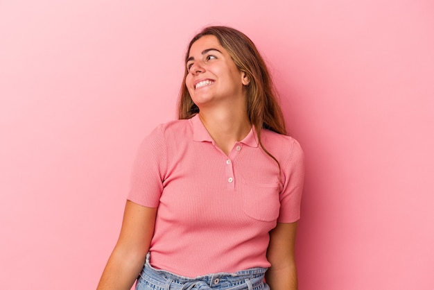 Junge kaukasische Frau isoliert auf rosafarbenem Hintergrund entspannt und glücklich lachend, Hals gestreckt, Zähne zeigend.
