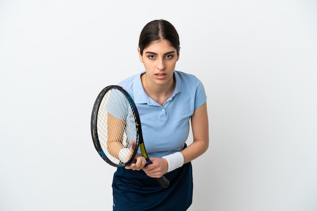 Junge kaukasische Frau isoliert auf weißem Hintergrund beim Tennisspielen