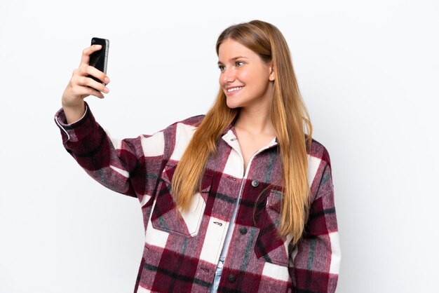 Junge kaukasische Frau isoliert auf weißem Hintergrund, die ein Selfie macht