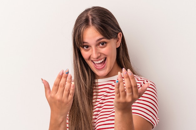 Junge kaukasische Frau isoliert auf weißem Hintergrund, die mit dem Finger auf Sie zeigt, als ob sie einladen würde, näher zu kommen.