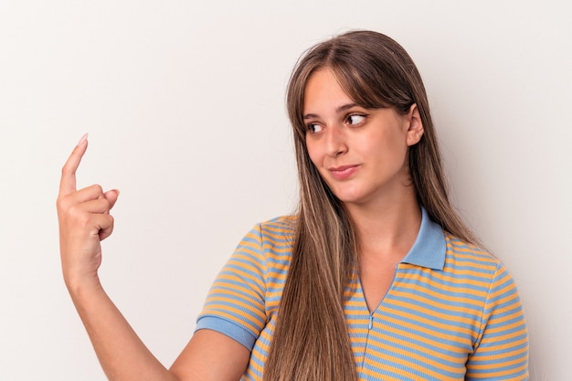 Junge kaukasische Frau isoliert auf weißem Hintergrund, die mit dem Finger auf Sie zeigt, als ob sie einladen würde, näher zu kommen.