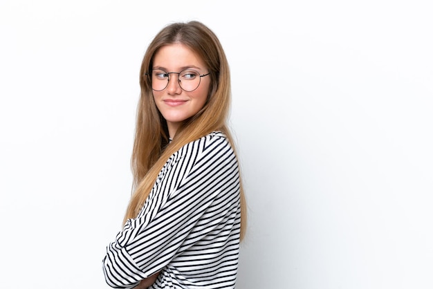 Junge kaukasische Frau isoliert auf weißem Hintergrund, die zur Seite schaut und lächelt