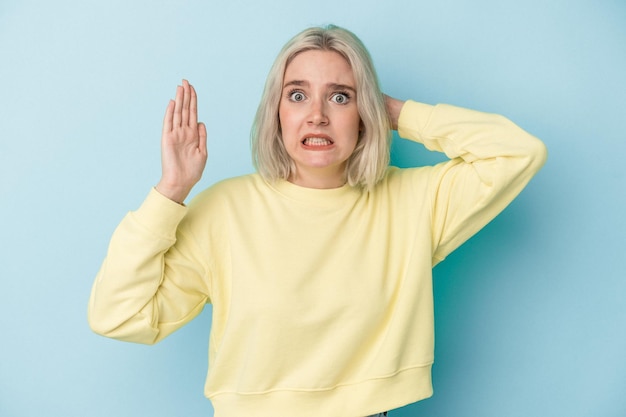 Foto junge kaukasische frau lokalisiert auf blauem hintergrund, die vor wut schreit.