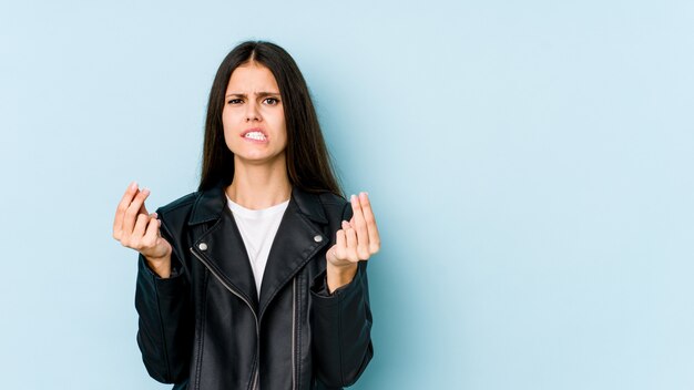 Junge kaukasische Frau lokalisiert auf blauer Wand, die zeigt, dass sie kein Geld hat.