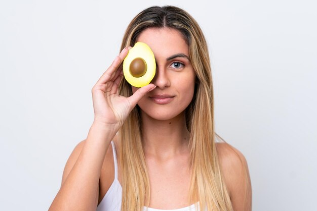 Junge kaukasische Frau lokalisiert auf weißem Hintergrund, der eine Avocado hält Close up Portrait