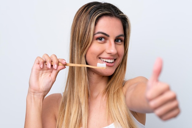 Junge kaukasische Frau lokalisiert auf weißem Hintergrund mit einer Zahnbürste